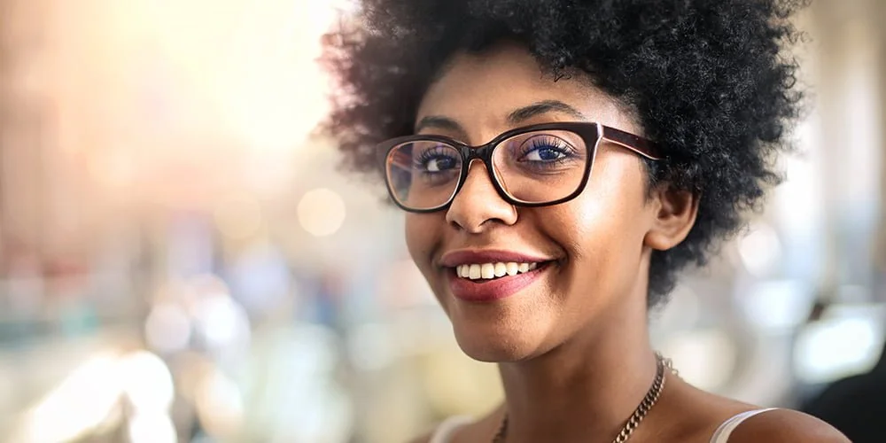 woman wearing dark rimmed glasses with Bokeh background 