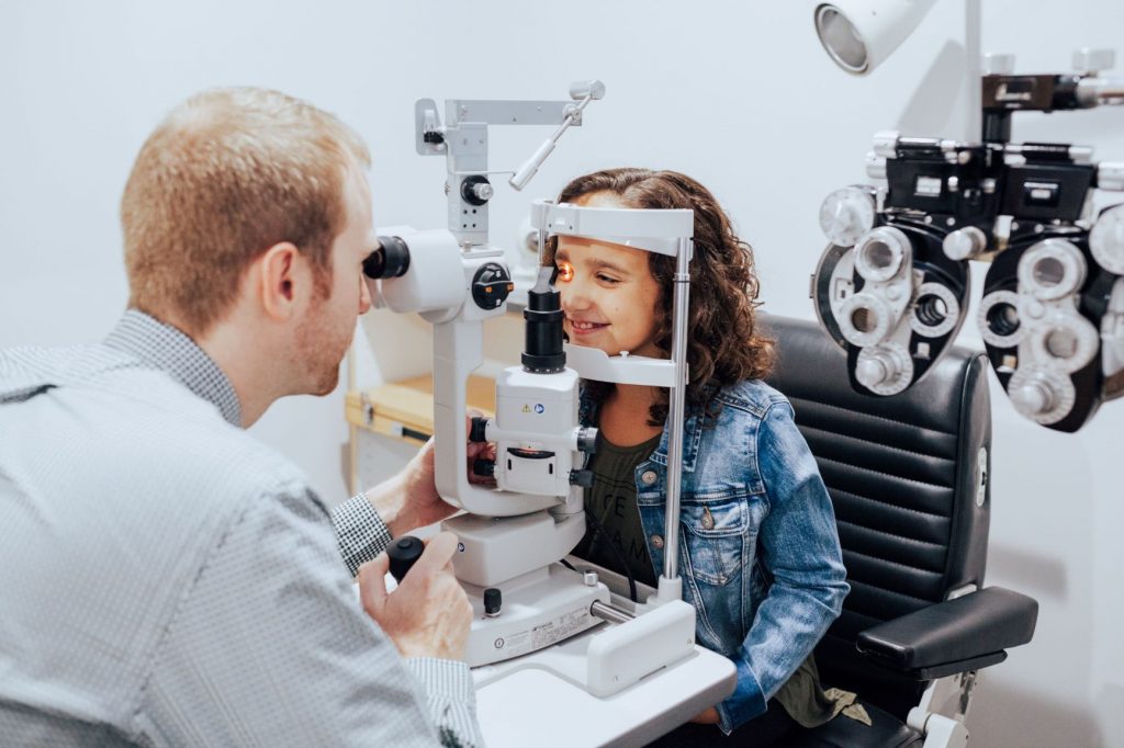 young girl getting eyes checked by an optometrist