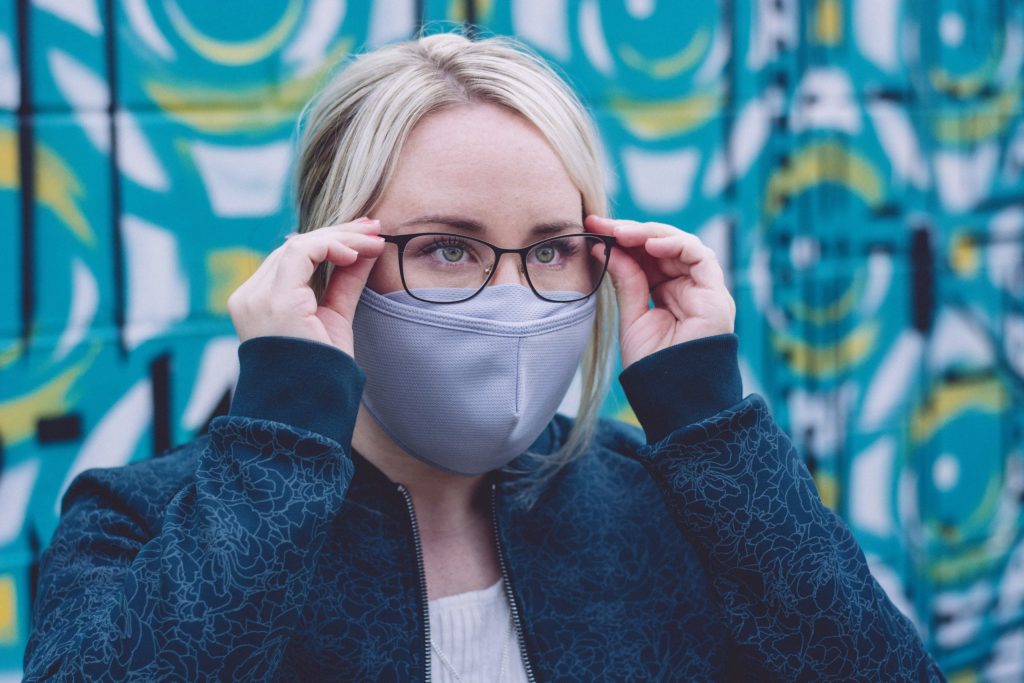 woman wearing glasses with a gray anti-fog face mask