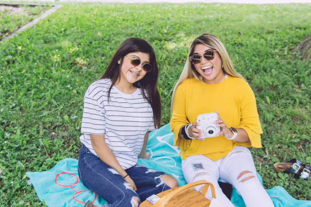 two women wearing sunglasses enjoying a spring picnic