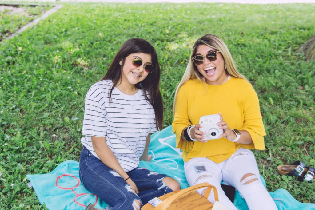 two women wearing sunglasses enjoying a spring picnic who manage seasonal eye allergies