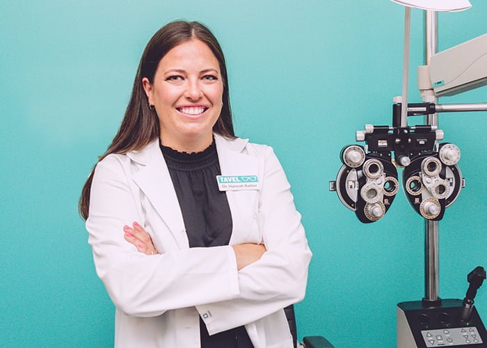 Female eye doctor standing and smiling with crossed arms