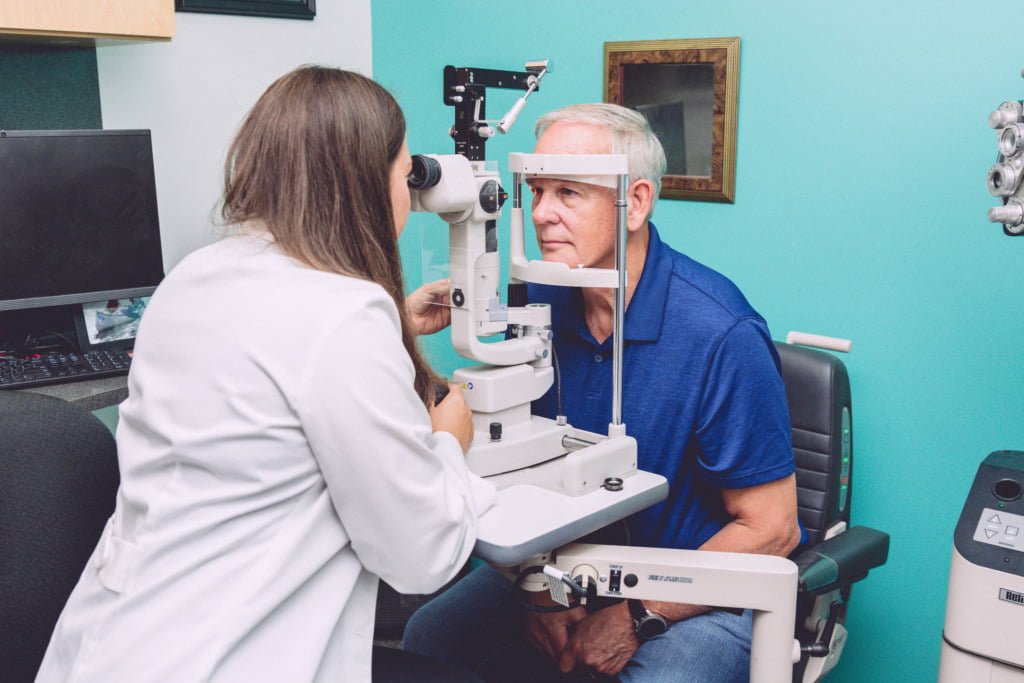 Optometrist using a slit lamp on a patient to check for macular degeneration and other eye diseases.